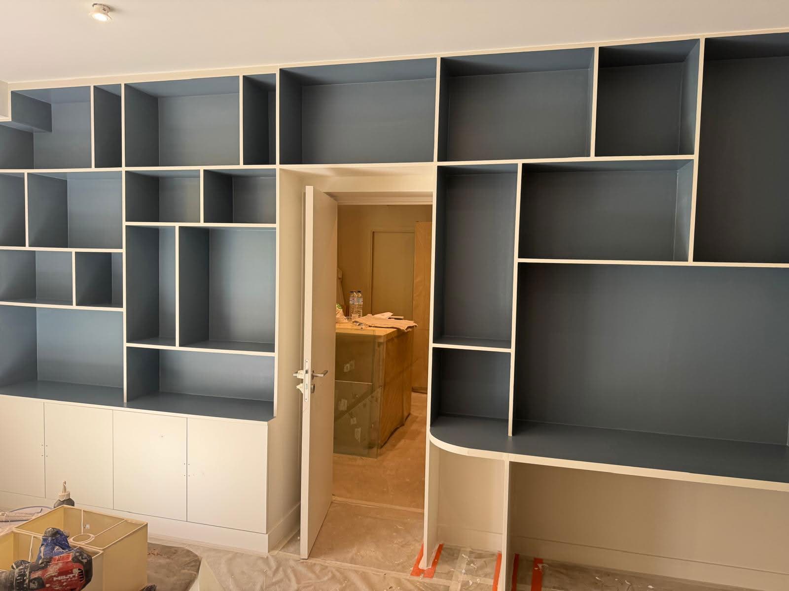 Grande bibliothèque sur mesure bleu-gris intégrée autour d'une porte