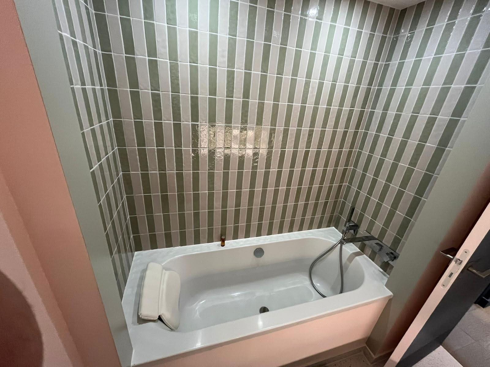 Salle de bain avec baignoire et zellige vertical vert et blanc